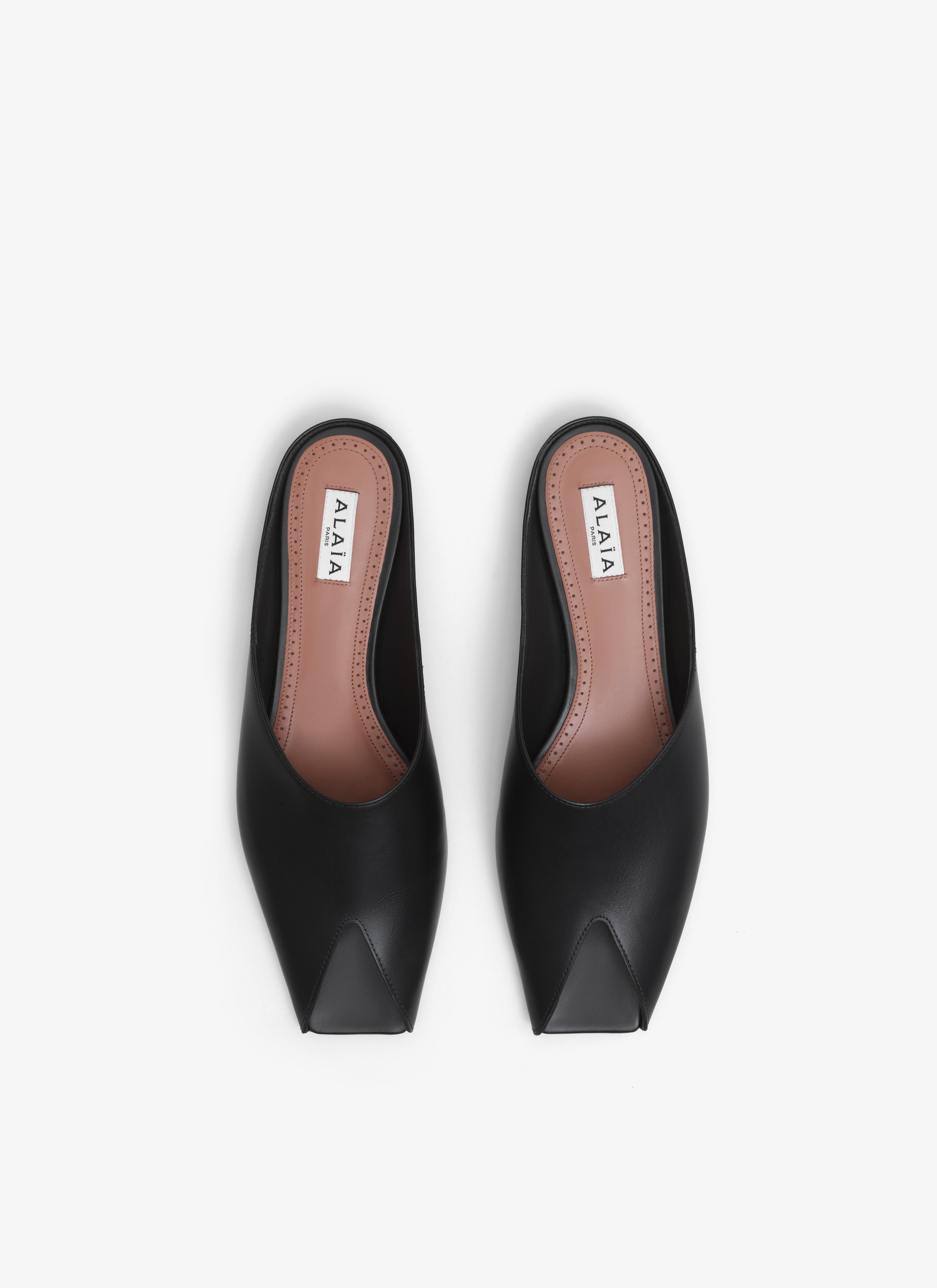 ALAÏA BLACK SPIKE FLAT MULES IN CALFSKIN