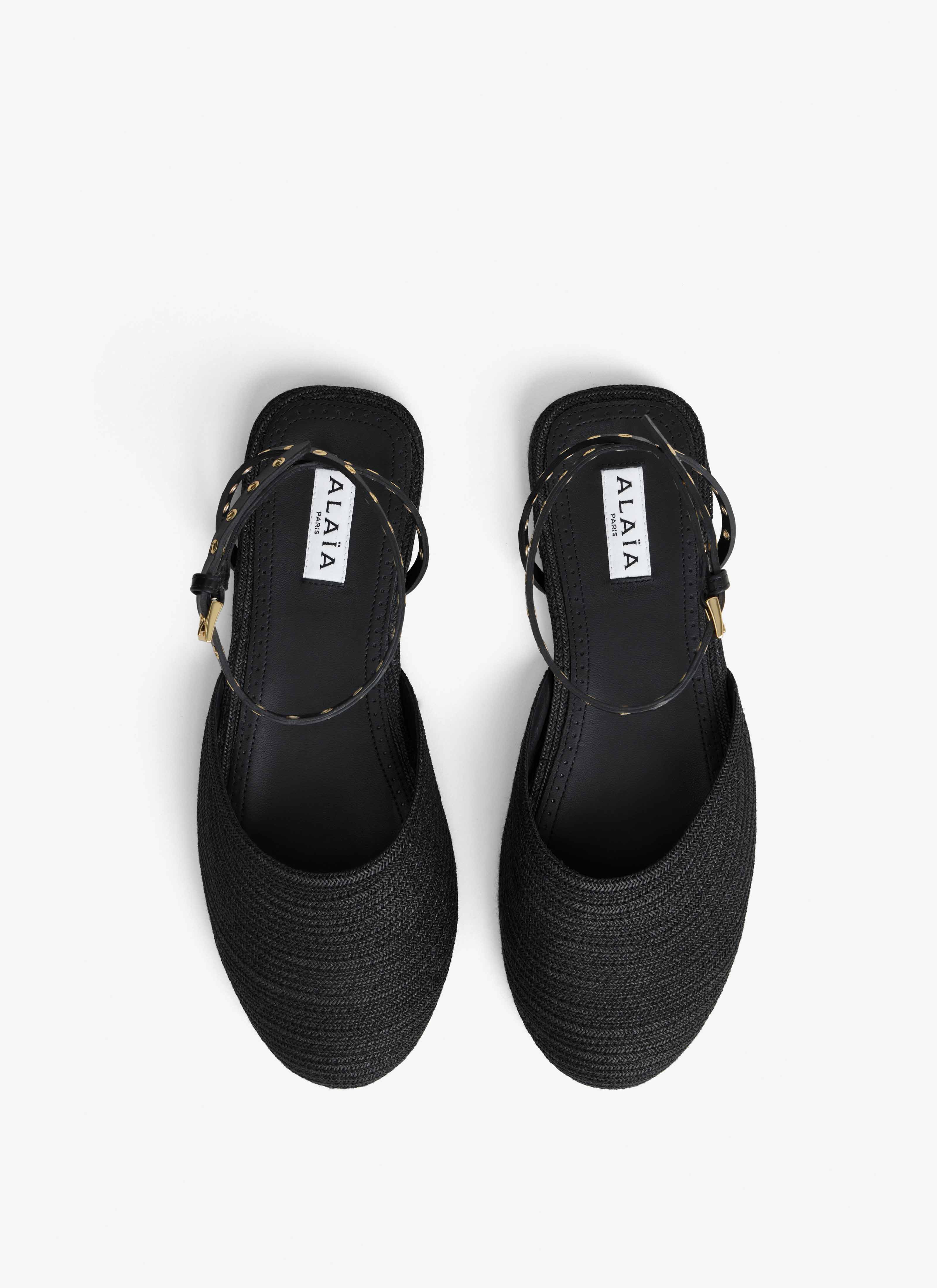 ALAÏA BLACK FLAT SANDALS IN PAPER STRAW
