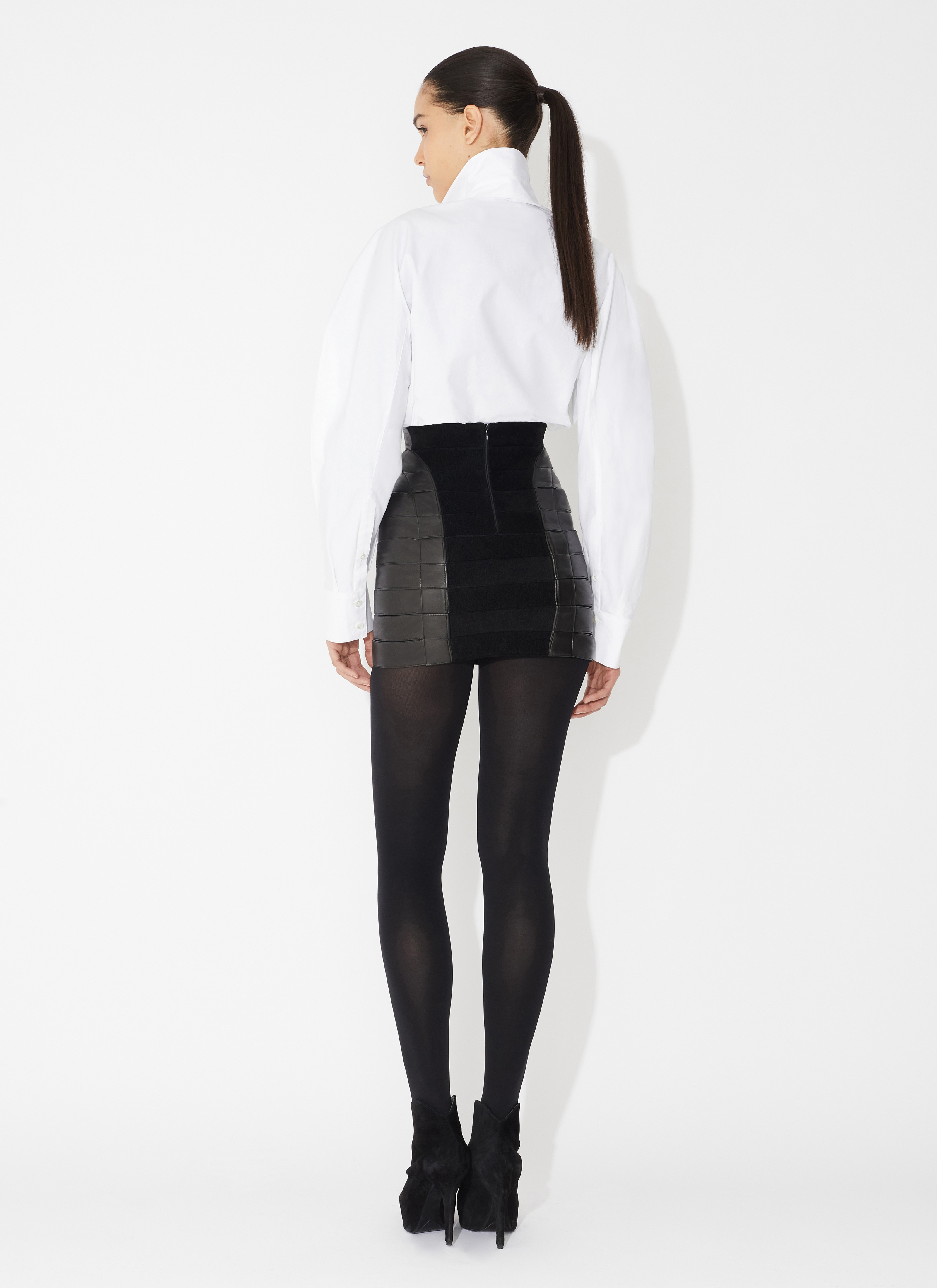 ALAÏA JUPE TUBE COURTE EN CUIR NOIR