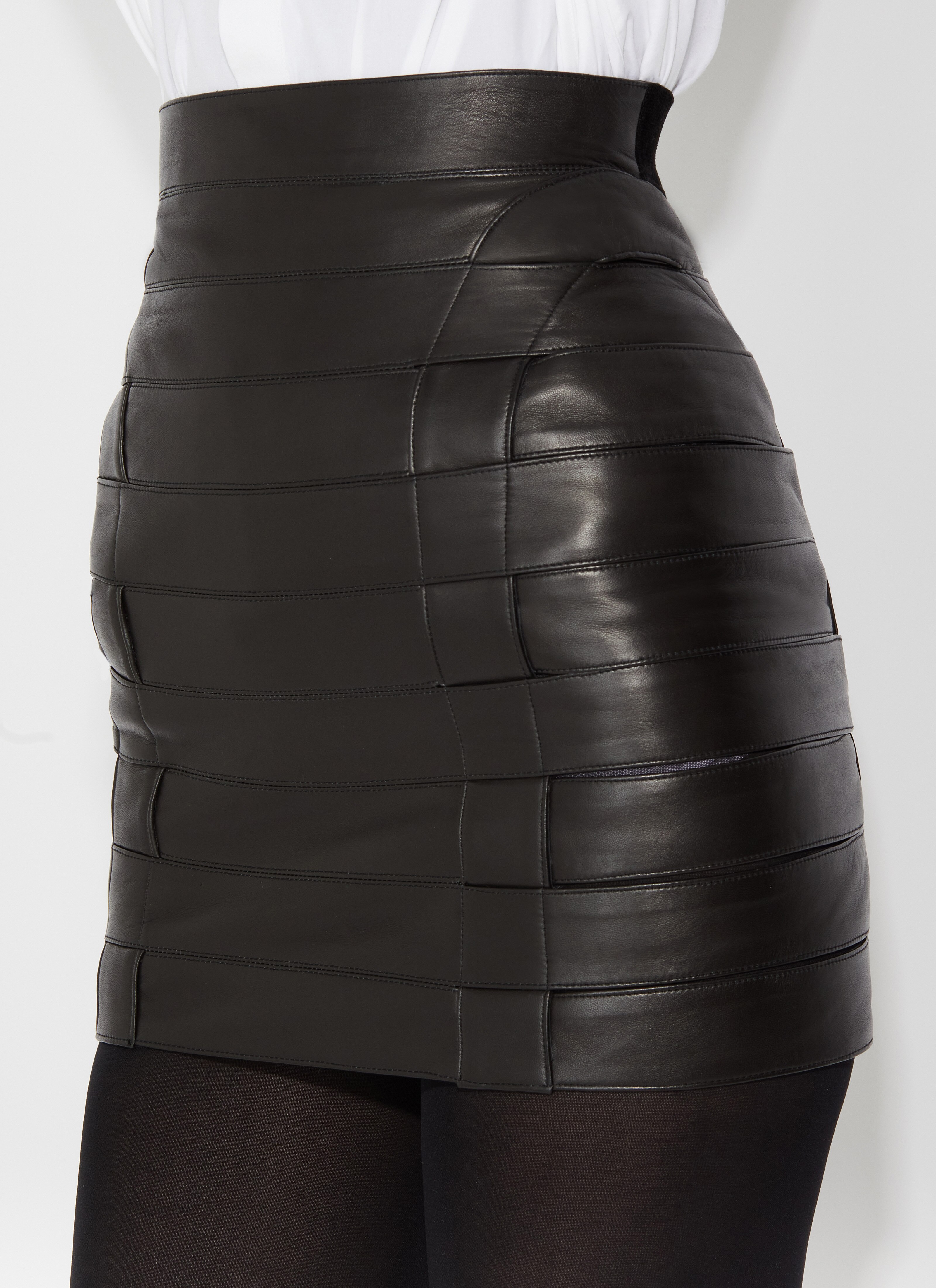 ALAÏA JUPE TUBE COURTE EN CUIR NOIR